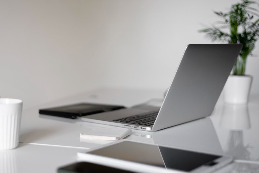 Two open laptops on a white office desk