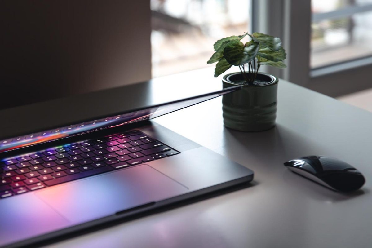 Laptop with an illuminated keyboard and mouse on a desk