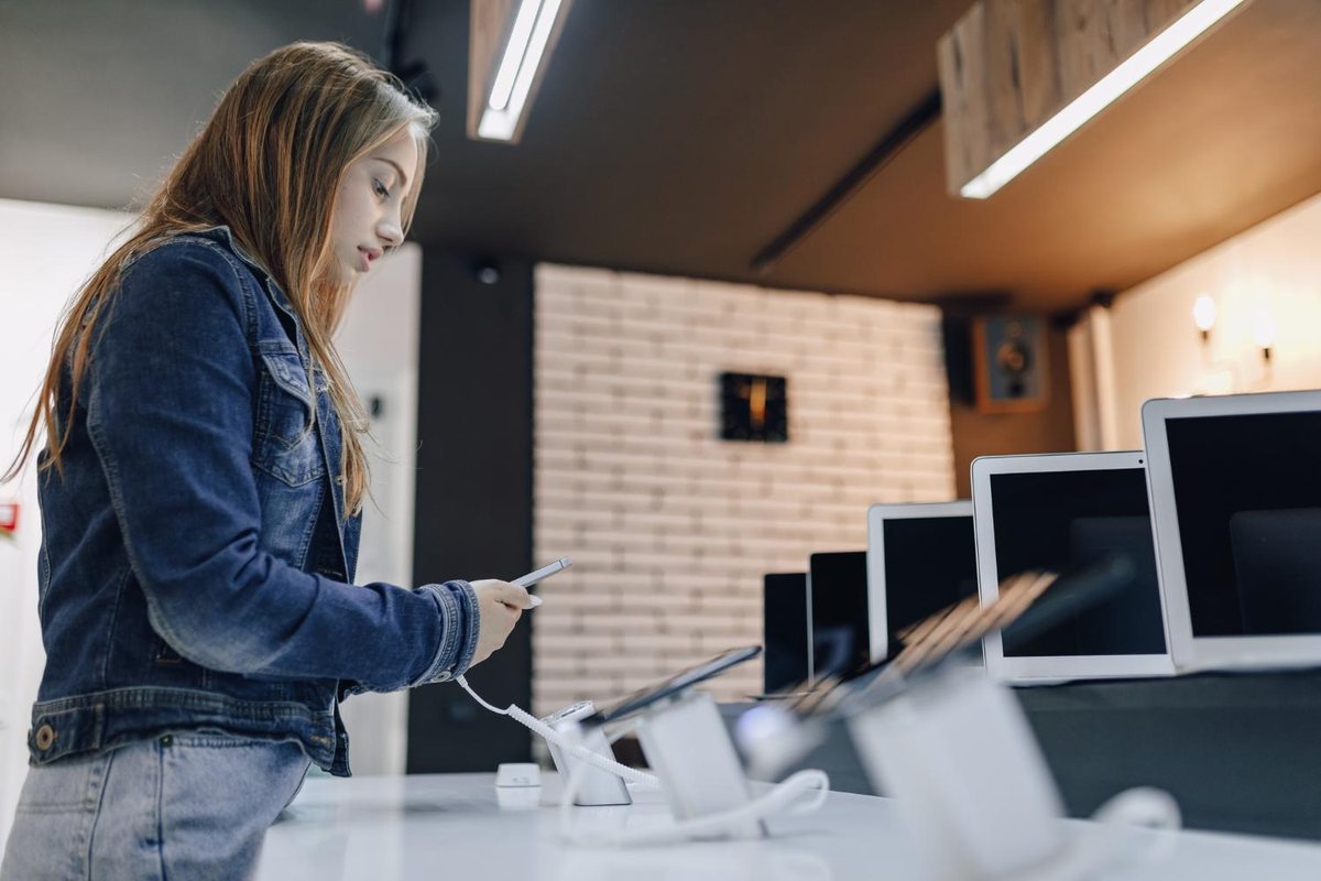 Customer browsing laptops displayed in a computer store