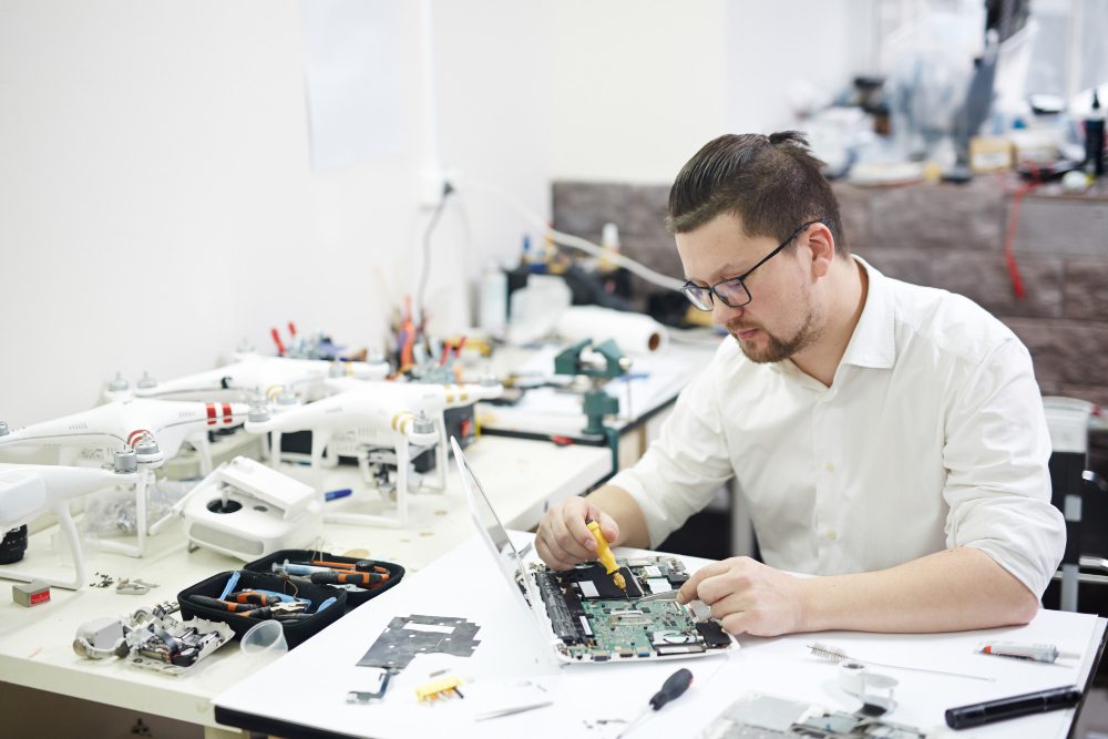 Technician working on computer components at a repair bench