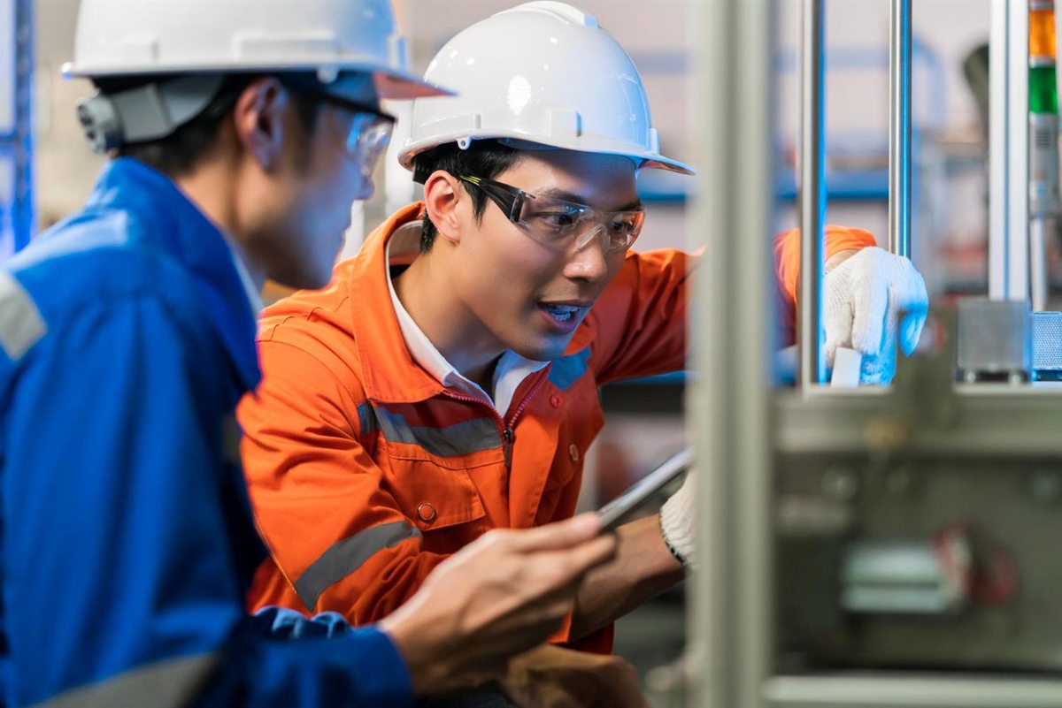 Workers inspecting equipment on a production line