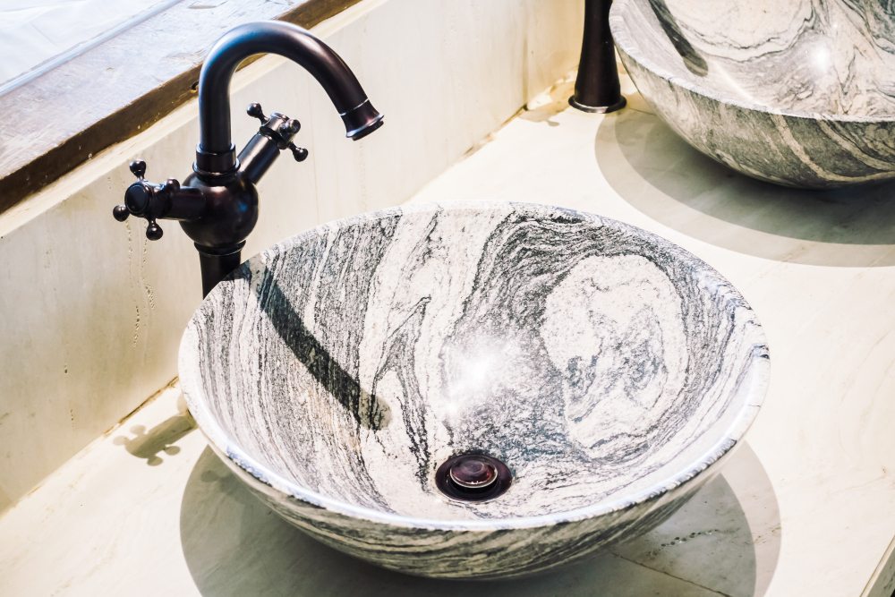 Marble-pattern countertop basin with a black tap